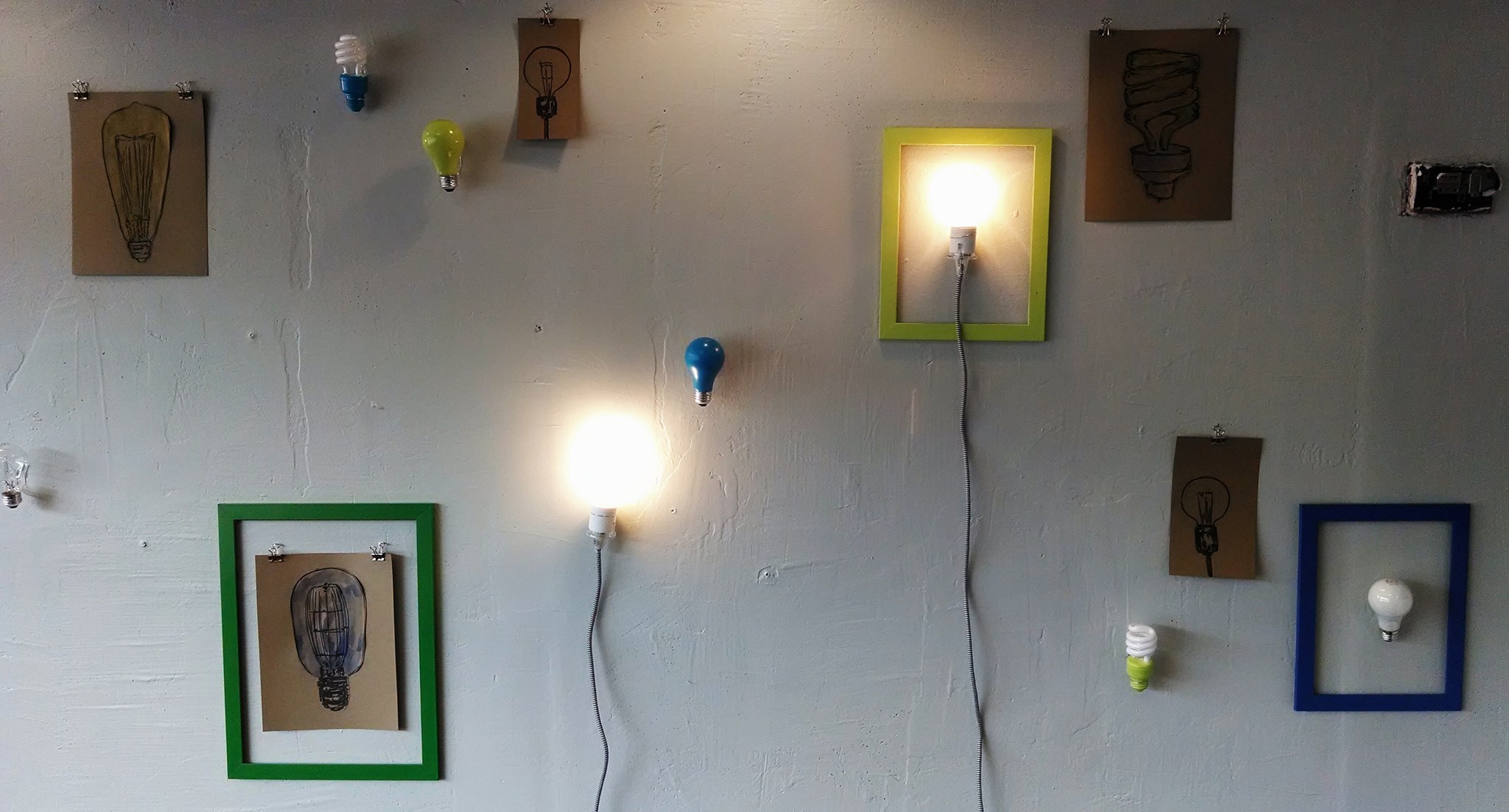 A wall with functioning lightbulbs and idea-inspired art at UpTo Wilkinsburg